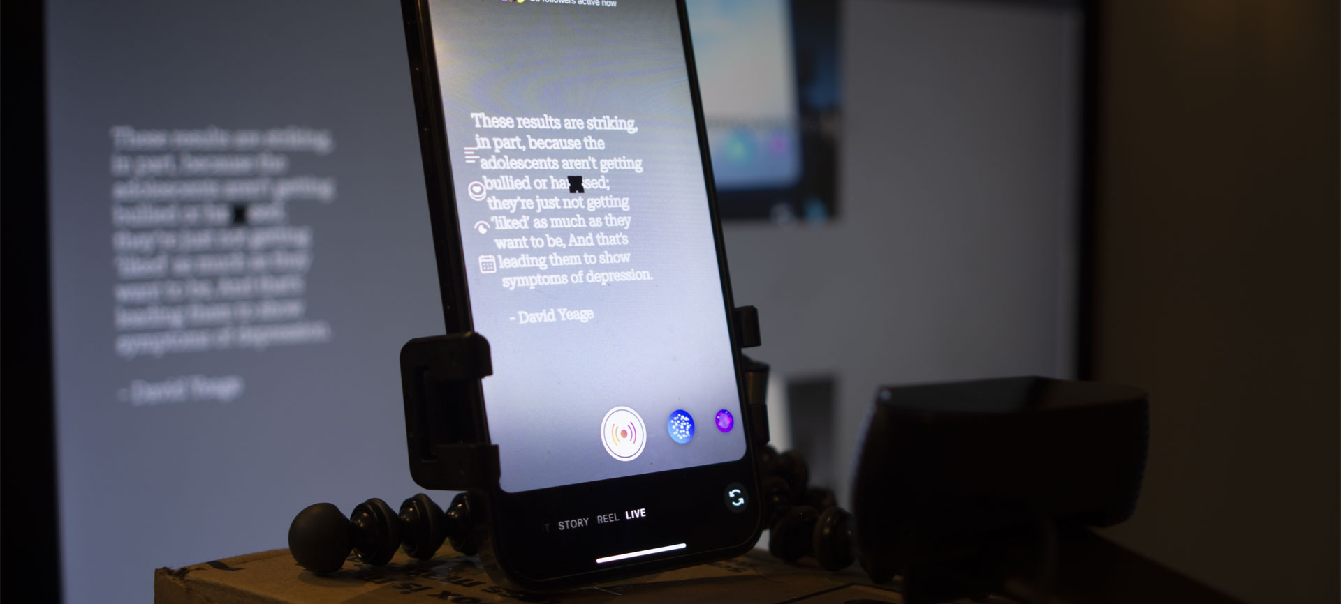 A behind the scenes photo of an iphone and webcam setup