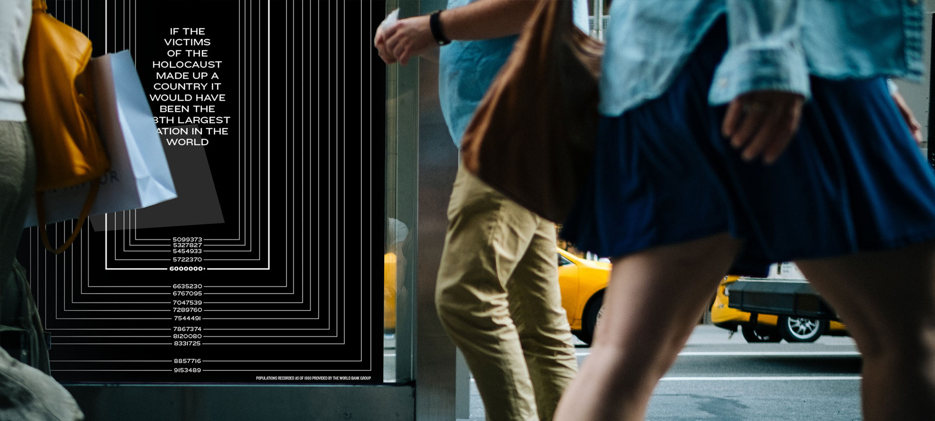 People walking by Holocaust poster